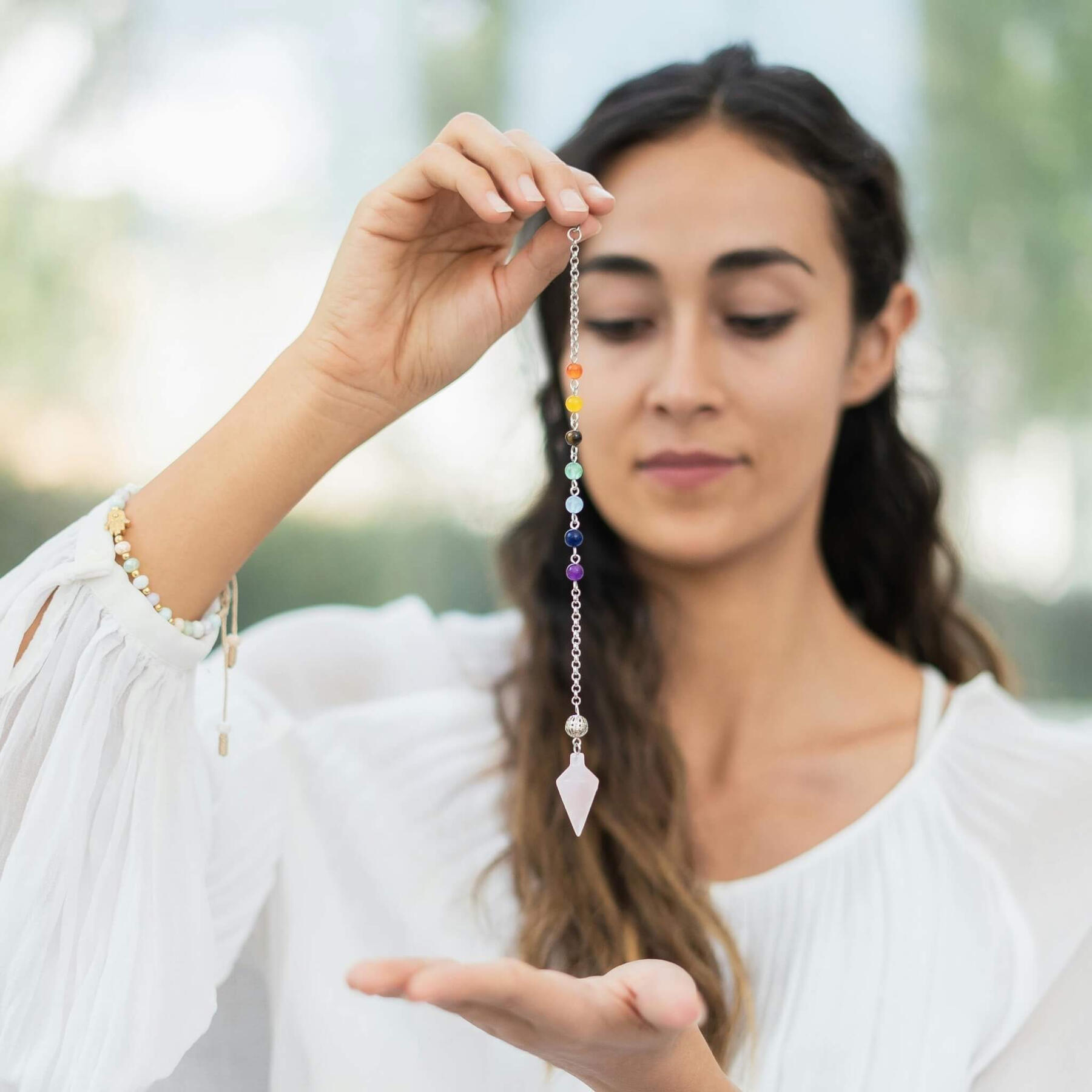 Crystal healing foundation This is a photo of a lady holding a crystal pendulum